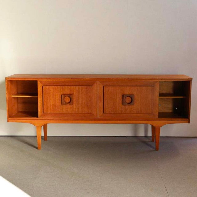 Mid-century British vintage teak sideboard with smooth wood grain, two central square-door compartments, open shelving on.