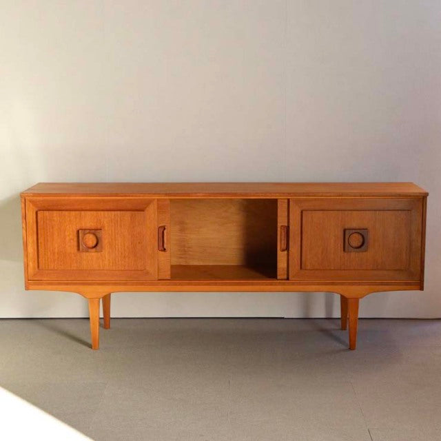 Mid-century vintage British teak sideboard with rich wood grain, square recessed handles, and tapered legs from Denmark style.