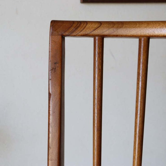 Mid-century vintage teak dining chair back with sharp clean lines and visible wood grain, British Scandinavian design.