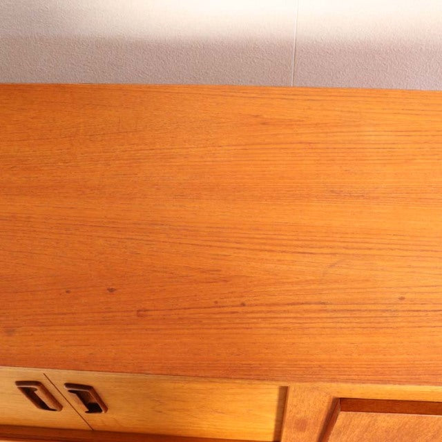 Vintage teak sideboard top with rich wood grain and warm mid-century British craftsmanship detail.