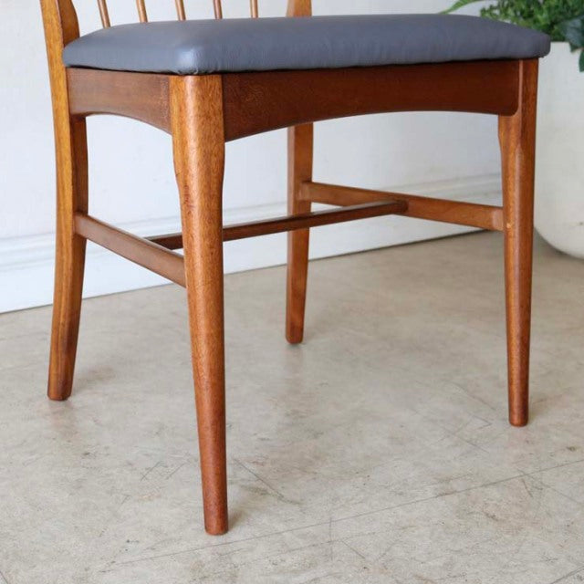 Vintage British mid-century teak dining chair with tapered legs and gray upholstered seat, showcasing natural wood grain and .