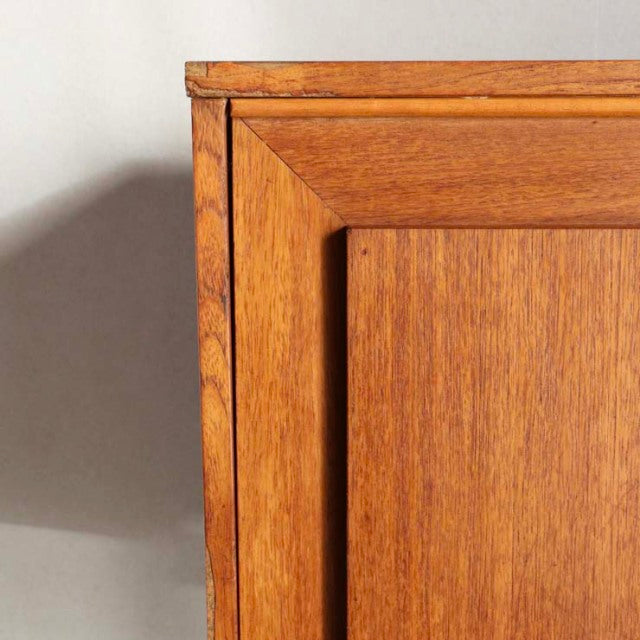 Close-up of vintage British teak sideboard door showcasing rich wood grain and mid-century craftsmanship.
