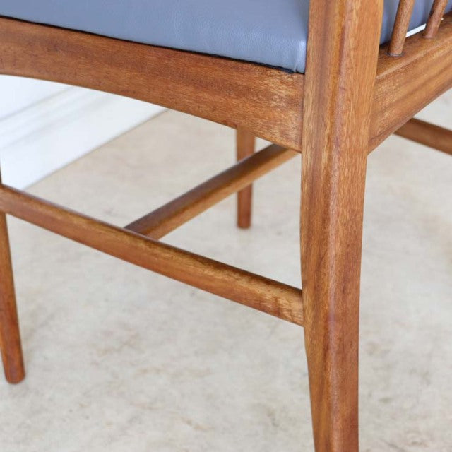 Mid-century British teak dining chair leg detail with warm wood grain and clean lines, vintage Denmark style.