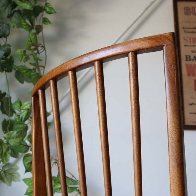 Vintage mid-century British teak dining chair back with smooth curved top rail and vertical spindle slats.