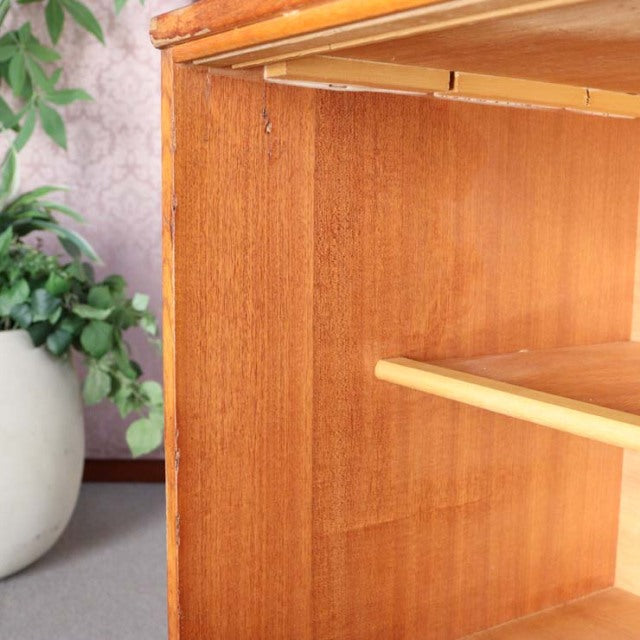 Mid-century British vintage teak sideboard corner showing rich wood grain and smooth shelf edges.