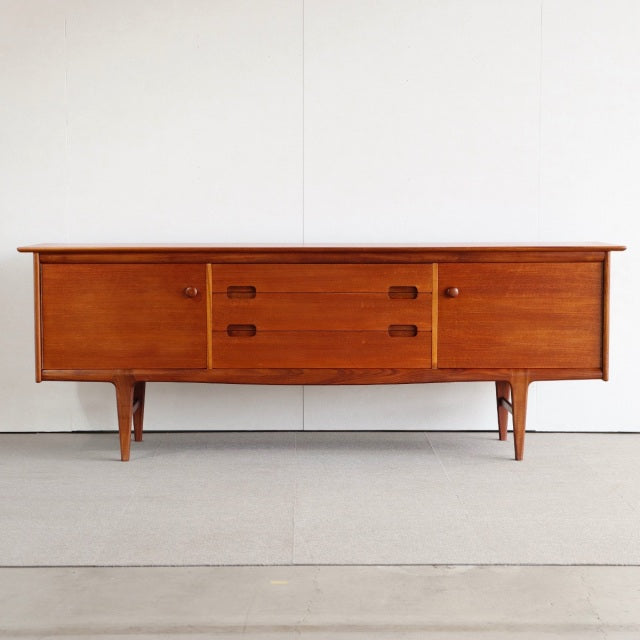 Mid-century British vintage teak sideboard by Younger with rich wood grain, tapered legs, two cupboards, and two central.
