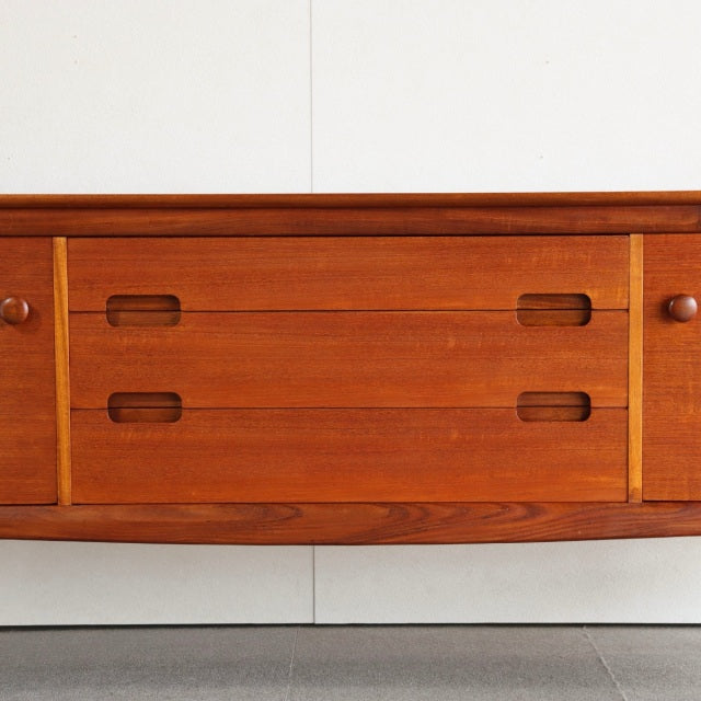 Vintage teak mid-century sideboard by YOUNGER with smooth wood grain, rounded edges, and integrated pull handles, showcasing .