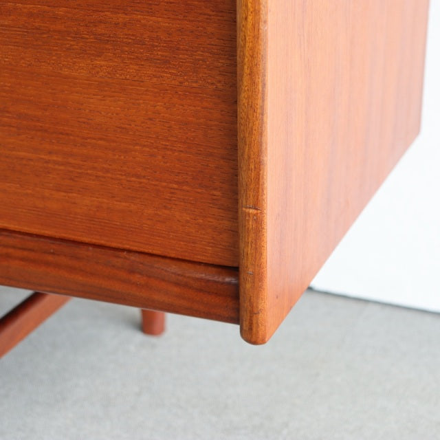 Close-up of vintage teak wood sideboard corner showing smooth grain, rounded edge, and mid-century British craftsmanship.
