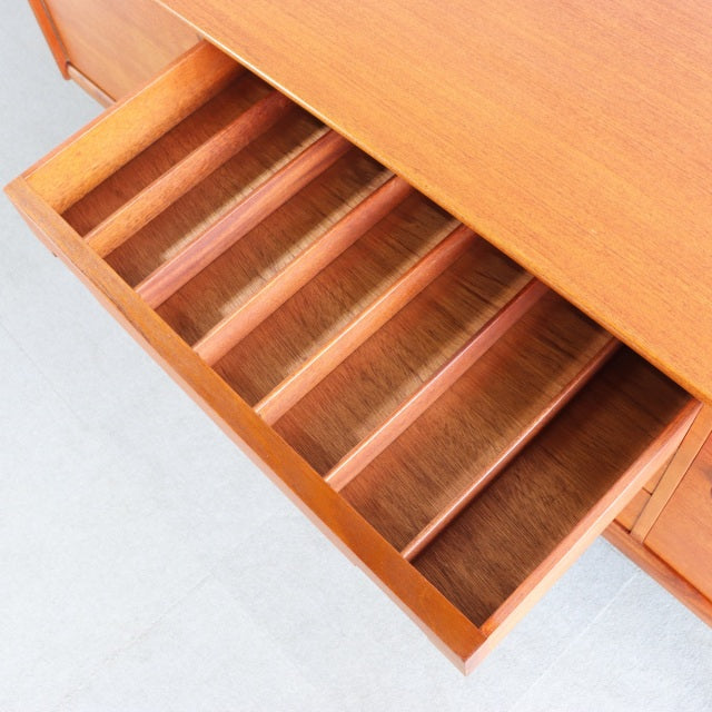 Vintage teak sideboard drawer open showing smooth wood grain and divided compartments, British mid-century design by YOUNGER.