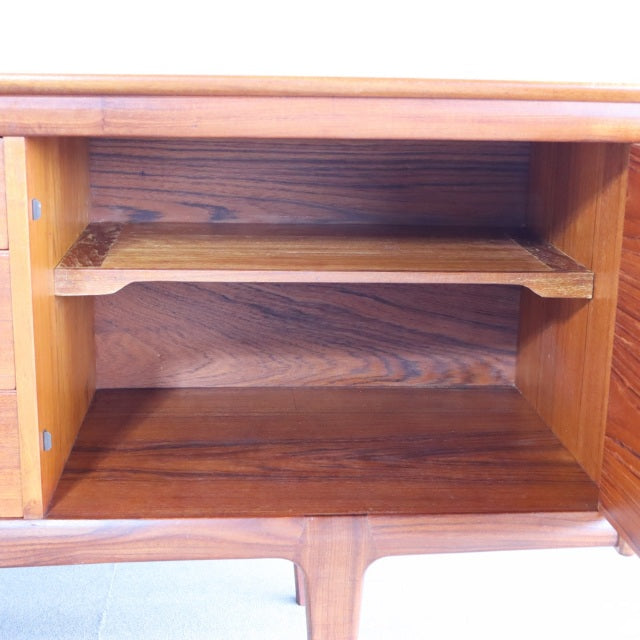 Mid-century British vintage teak sideboard interior showing rich wood grain and shelf, smooth finish, Denmark design.