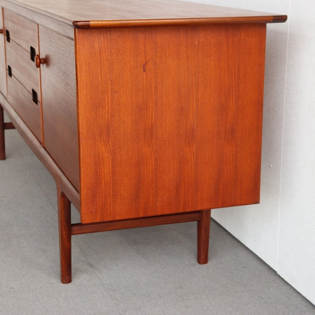 Mid-century British vintage teak sideboard by Younger with rich wood grain and slender tapered legs.