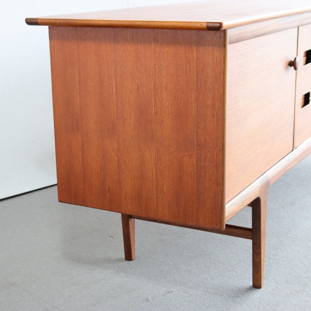 Vintage teak sideboard by Younger with warm wood grain, clean mid-century British design, and slender tapered legs from.
