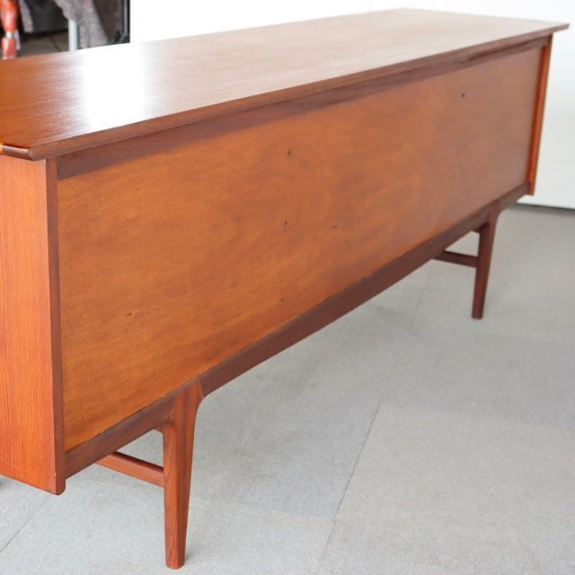 Vintage teak sideboard by Younger, mid-century British design with clean lines and tapered legs, smooth wood grain finish,.