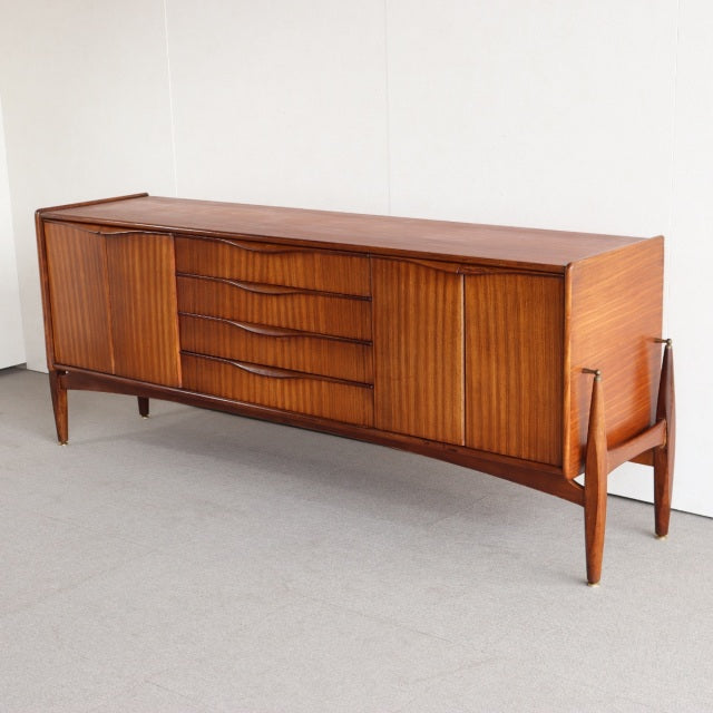 British mid-century vintage teak sideboard by Elliotts of Newbury with fluted cabinet doors and sculpted tapered legs.