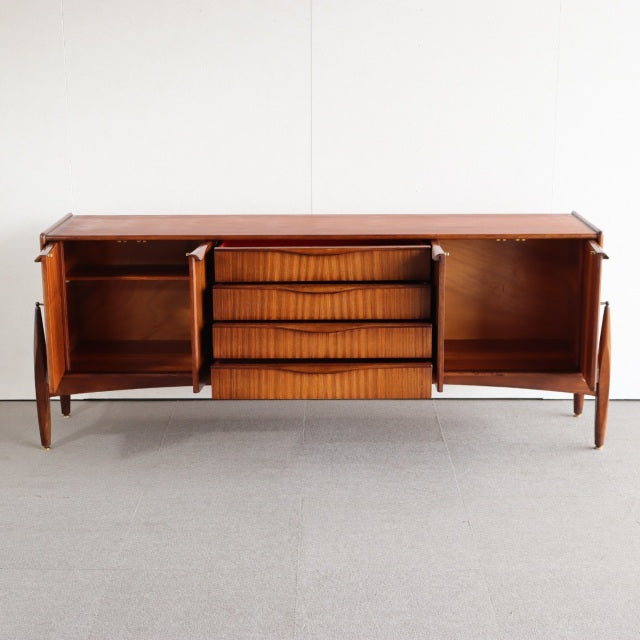 Mid-century British vintage teak sideboard by Elliotts of Newbury with smooth wood grain, central drawers, and side cabinets .