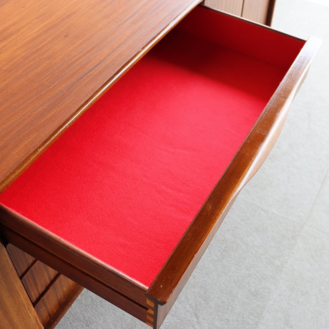 Open teak drawer with vibrant red felt lining, showcasing mid-century British craftsmanship by Elliotts of Newbury.