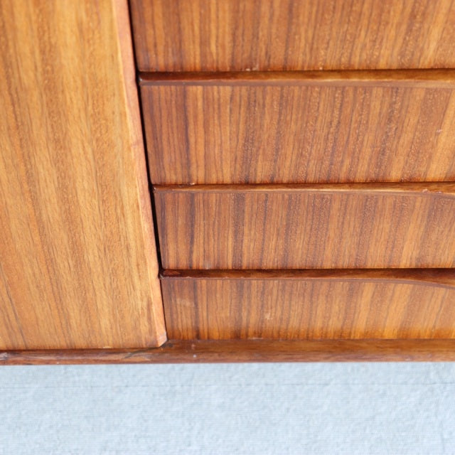 Close-up of vintage British mid-century teak sideboard drawer fronts showing warm wood grain and clean lines.