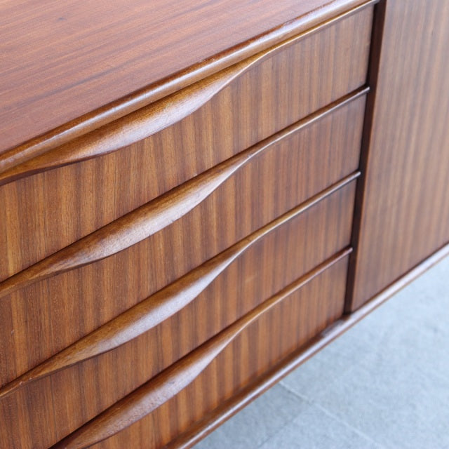British mid-century teak sideboard by Elliotts of Newbury featuring curved drawer handles and rich wood grain.