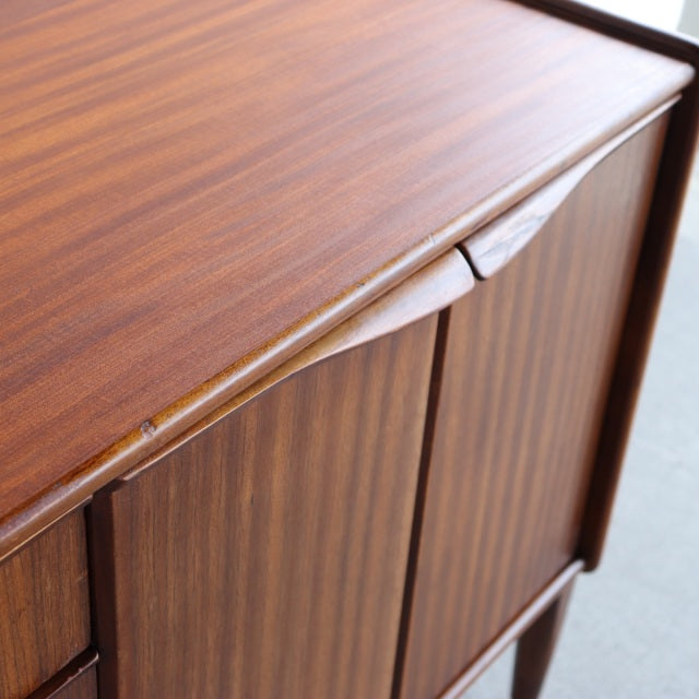 Vintage British mid-century teak sideboard by Elliotts of Newbury with smooth wood grain and tapered legs.