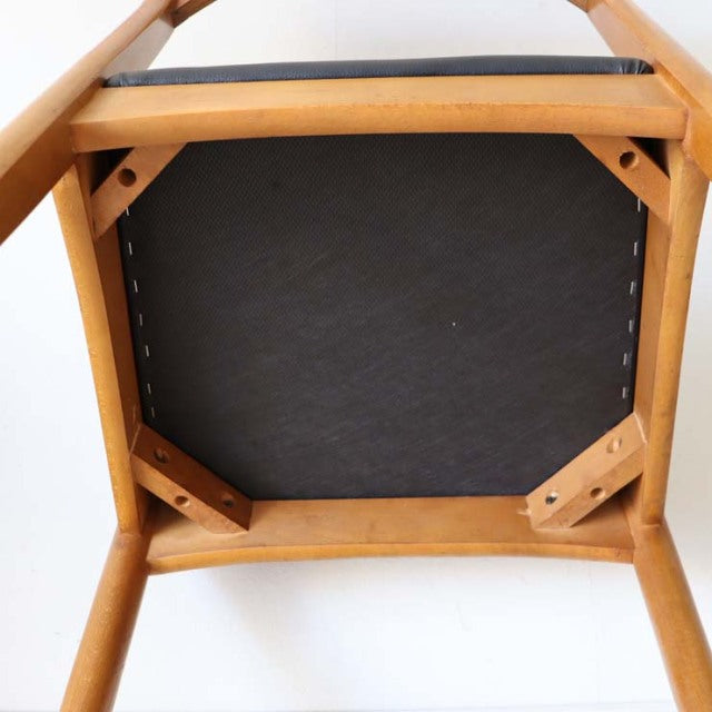 Mid-century British vintage teak dining chair with black seat, visible wood grain and sturdy angled legs, Denmark style.
