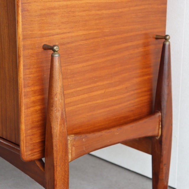 Vintage teak sideboard corner with rich wood grain, tapered British mid-century legs, and sturdy frame detail.