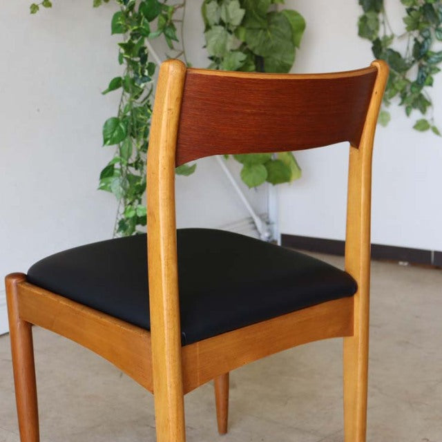 Vintage mid-century teak dining chair with black upholstered seat, curved backrest, slender legs, British-Denmark design.
