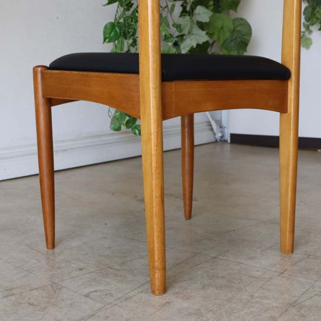 Vintage British teak dining chair with black upholstered seat, slender tapered legs, elegant mid-century Danish design,.