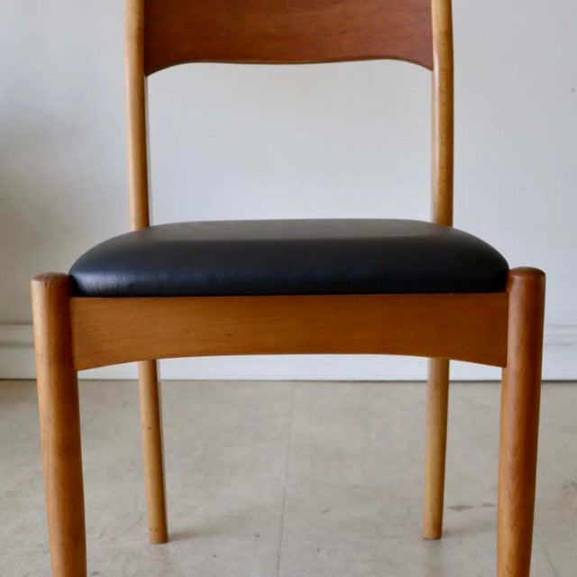 Vintage mid-century British teak dining chair with smooth wood grain and black upholstered seat.