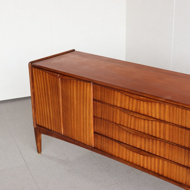 Vintage teak British mid-century sideboard by Elliotts of Newbury with fluted door and four drawers, slender tapered legs,.