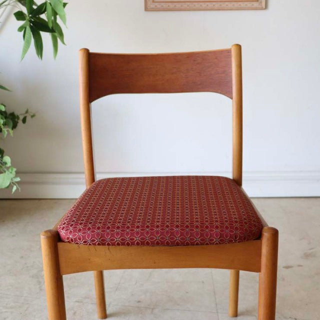 Vintage mid-century teak dining chair with curved backrest and red patterned flower seat cushion, classic British-Danish.