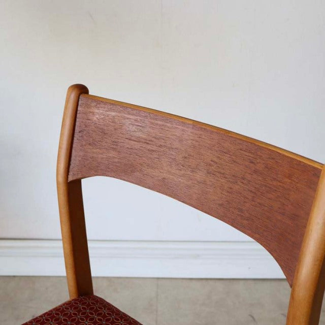 Vintage teak dining chair with curved backrest, visible wood grain, British mid-century design, smooth rounded legs.