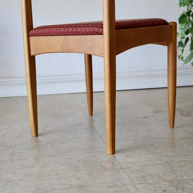 Vintage British mid-century teak dining chair with tapered legs and red floral upholstered seat.