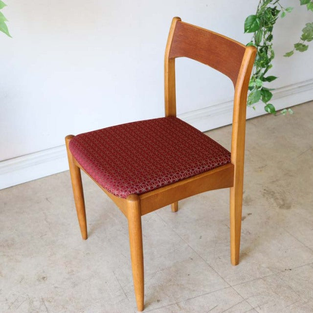 Mid-century British vintage teak dining chair from Denmark with smooth curved backrest and red patterned flower seat cushion.