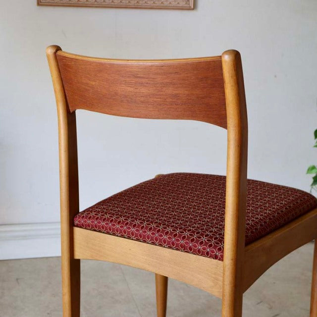 Vintage British mid-century teak dining chair with rich wood grain and red patterned flower seat, Danish design influence.
