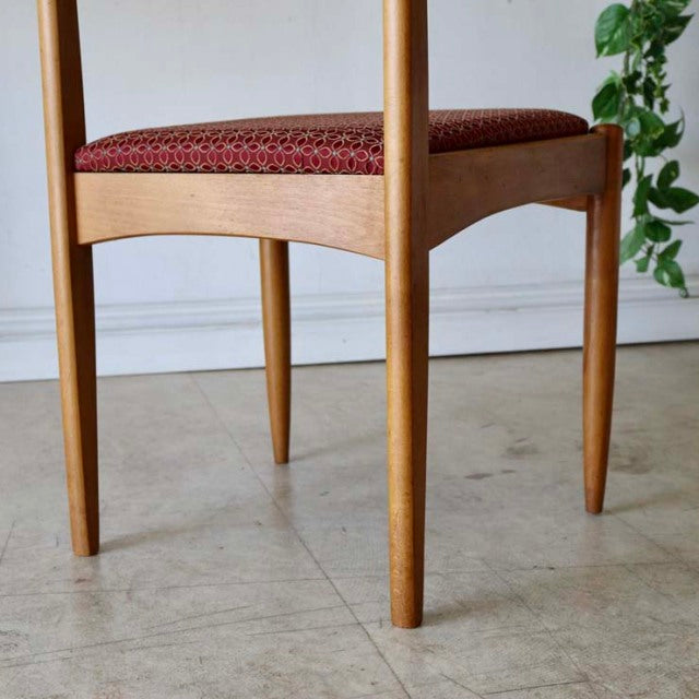 Vintage British mid-century teak dining chair from Denmark with smooth wood grain and tapered legs, featuring a burgundy.