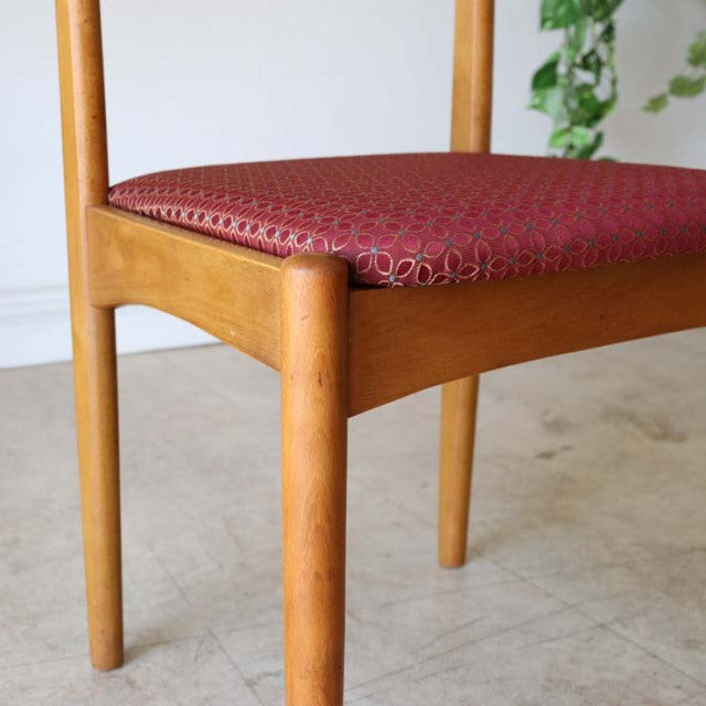 Vintage British mid-century teak dining chair from Denmark with warm wood grain and patterned red flower seat cushion.