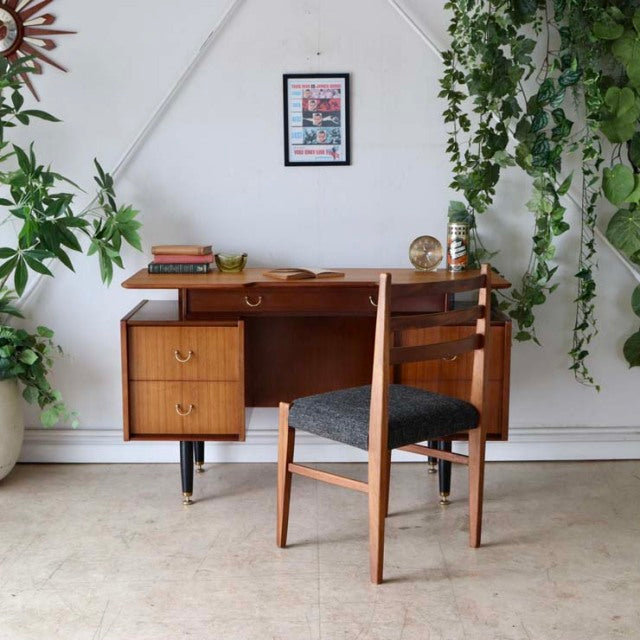 Vintage British mid-century teak desk by G-PLAN with rich wood grain, clean lines, three drawers on left, paired with.