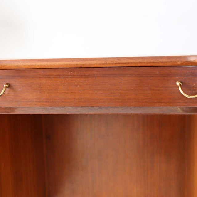Vintage British mid-century teak desk drawer with brass curved handles and smooth wood grain finish.