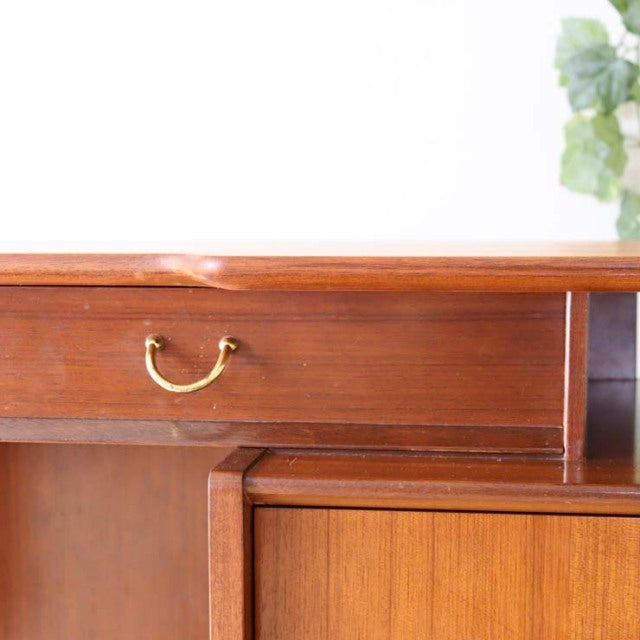 Vintage teak G-Plan desk drawer with brass handle, mid-century British design, smooth wood grain, and clean lines.