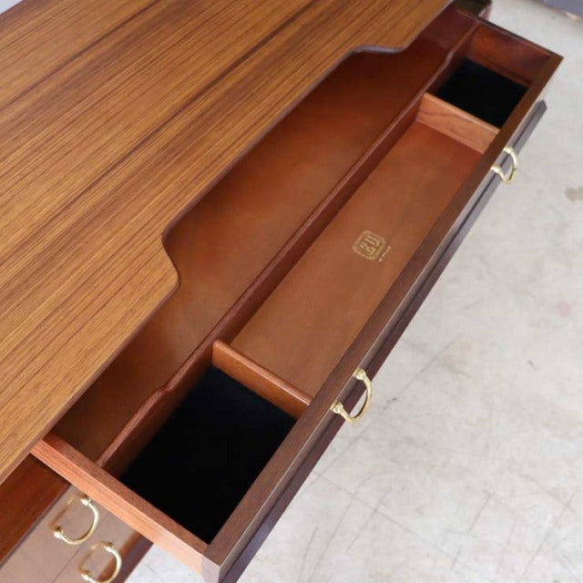 Vintage G-Plan teak desk drawer open showing smooth wood grain, brass handles, and mid-century British design details.