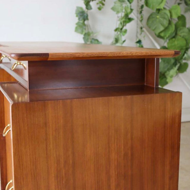 Vintage teak G-Plan desk with rich wood grain, mid-century British design, clean lines, and brass handles.