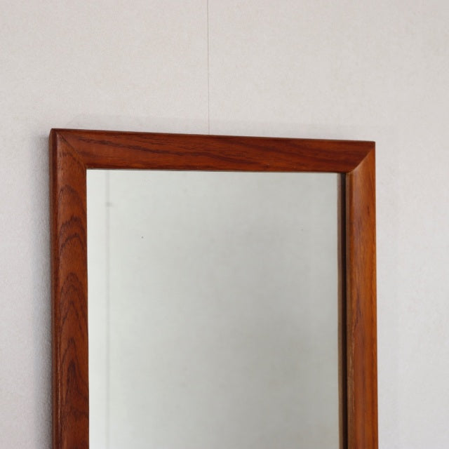 Vintage mid-century British teak wall mirror with rectangular frame and rich wood grain from Denmark.