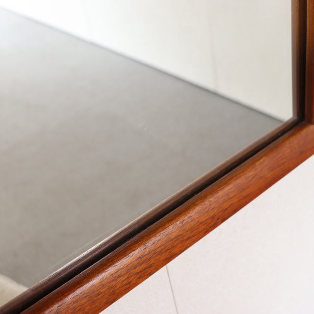 Vintage mid-century teak wall mirror with clean rectangular frame, smooth wood grain, British-Denmark style.
