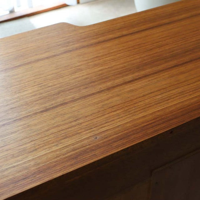 Vintage teak desk surface with rich wood grain showcasing British mid-century design by G-PLAN.