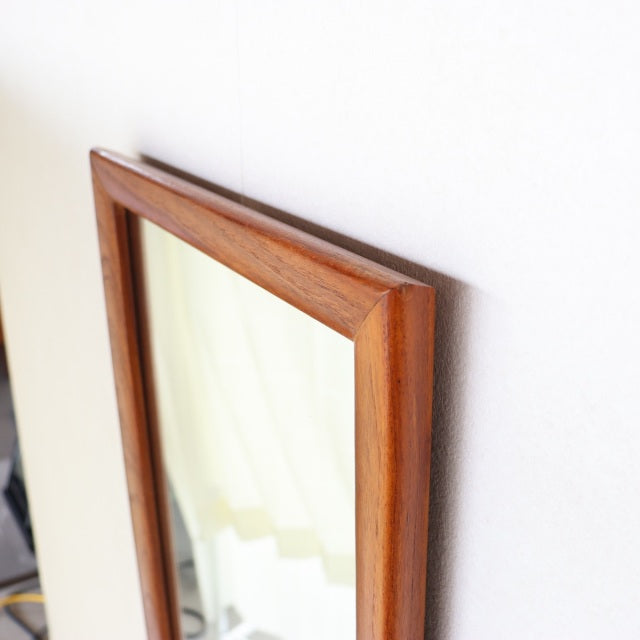 Vintage mid-century British teak wall mirror with rectangular frame, showcasing rich wood grain and smooth beveled edges.