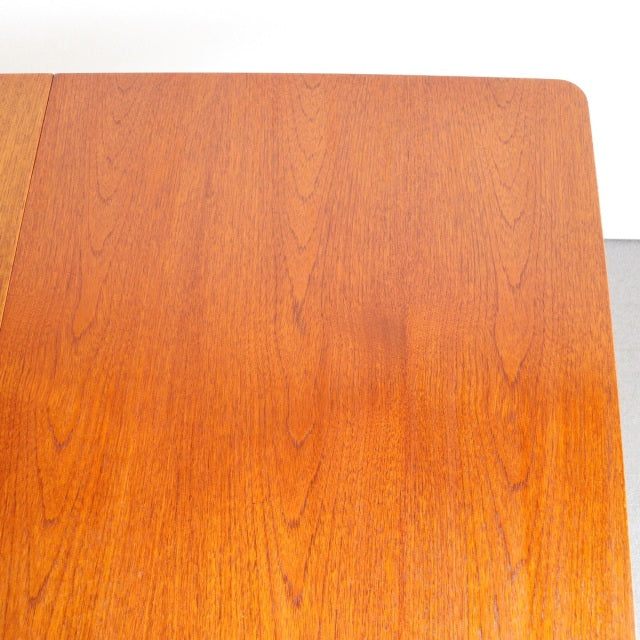Vintage teak dining table top with smooth wood grain, mid-century British and Danish design influence, rectangular shape.