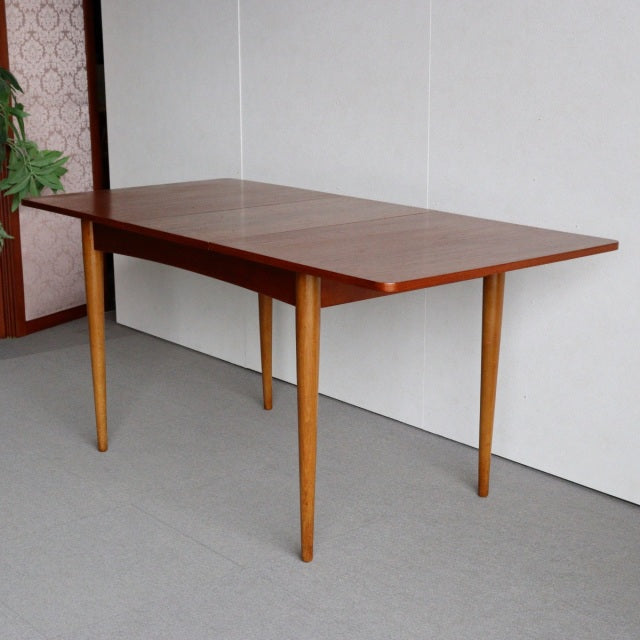 Mid-century British vintage teak dining table with smooth wood grain and tapered legs, Danish style.