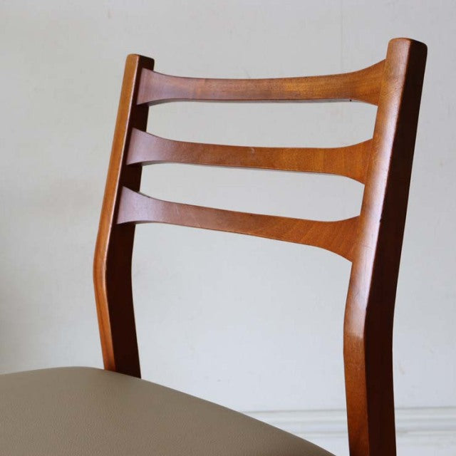 Set of four vintage mid-century teak dining chairs from Britain and Denmark with curved backrest slats and white.