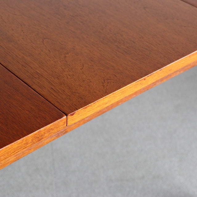 Vintage teak dining table corner showcasing rich wood grain and mid-century British-Denmark craftsmanship.