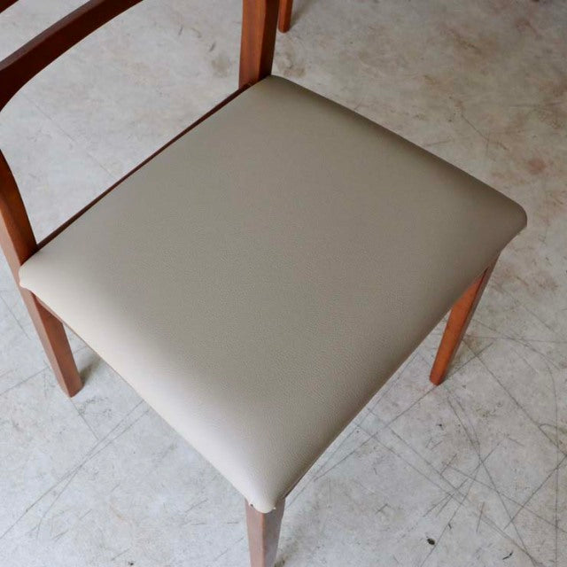 Set of four vintage teak dining chairs with smooth cream-colored upholstered seats, British mid-century design, slender.